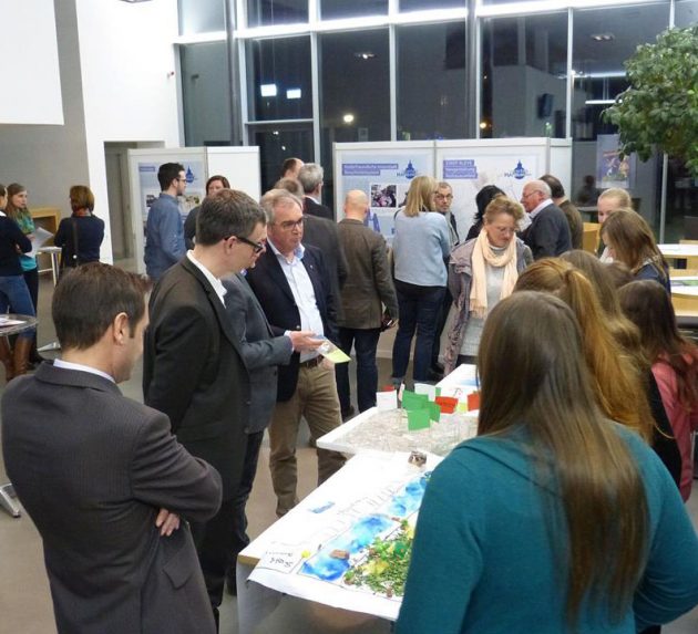 Bürgerinnen und Bürger diskutieren bei einer Beteiligungsveranstaltung an einem Stadtmodell
