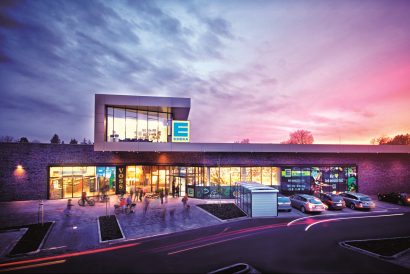 Beleuchteter EDEKA Markt mit Parkplatz in der Abenddämmerung in Neuenkirchen