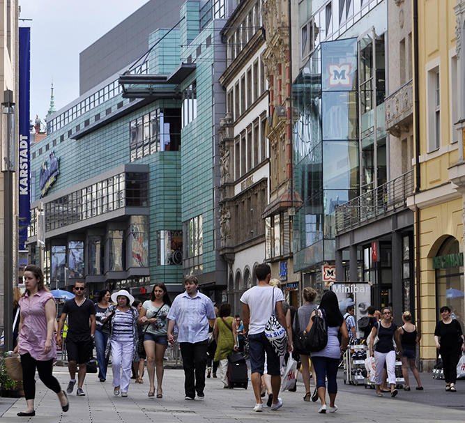 Belebte Fußgängerzone mit Passanten vor dem Kaufhaus Karstadt und modernen Geschäftshäusern