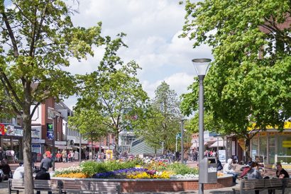 Fußgängerzone Tibarg in Hamburg mit Bäumen, Blumenbeet, Sitzbänken und Passanten