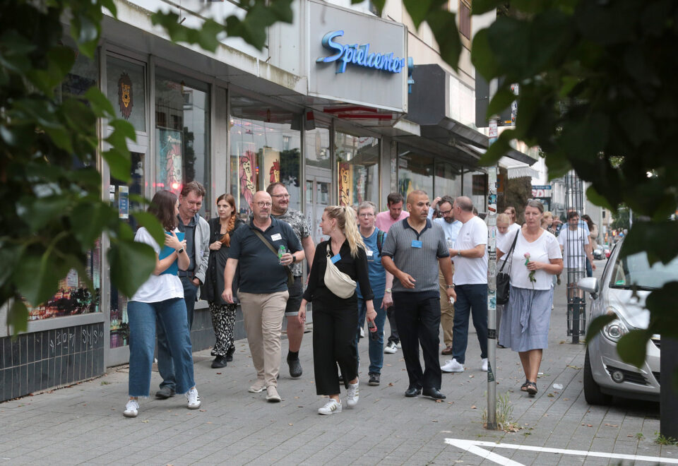 Gruppe mit Namensschildern bei einem Stadtrundgang durch eine Einkaufsstraße