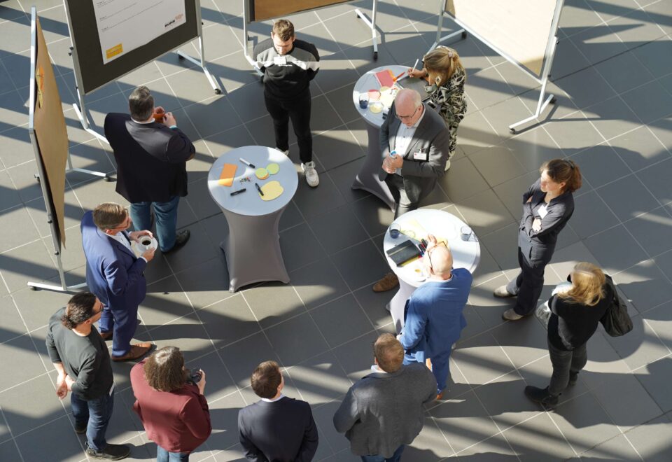 Teilnehmende des Innenstadtdialogs an Stehtischen und Pinnwänden, von oben fotografiert